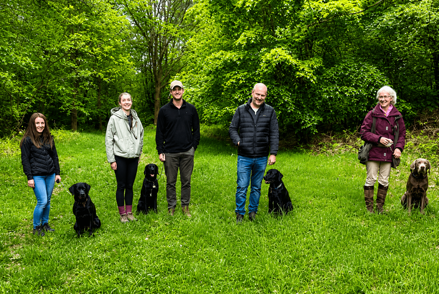 Group posing with dogs in green park