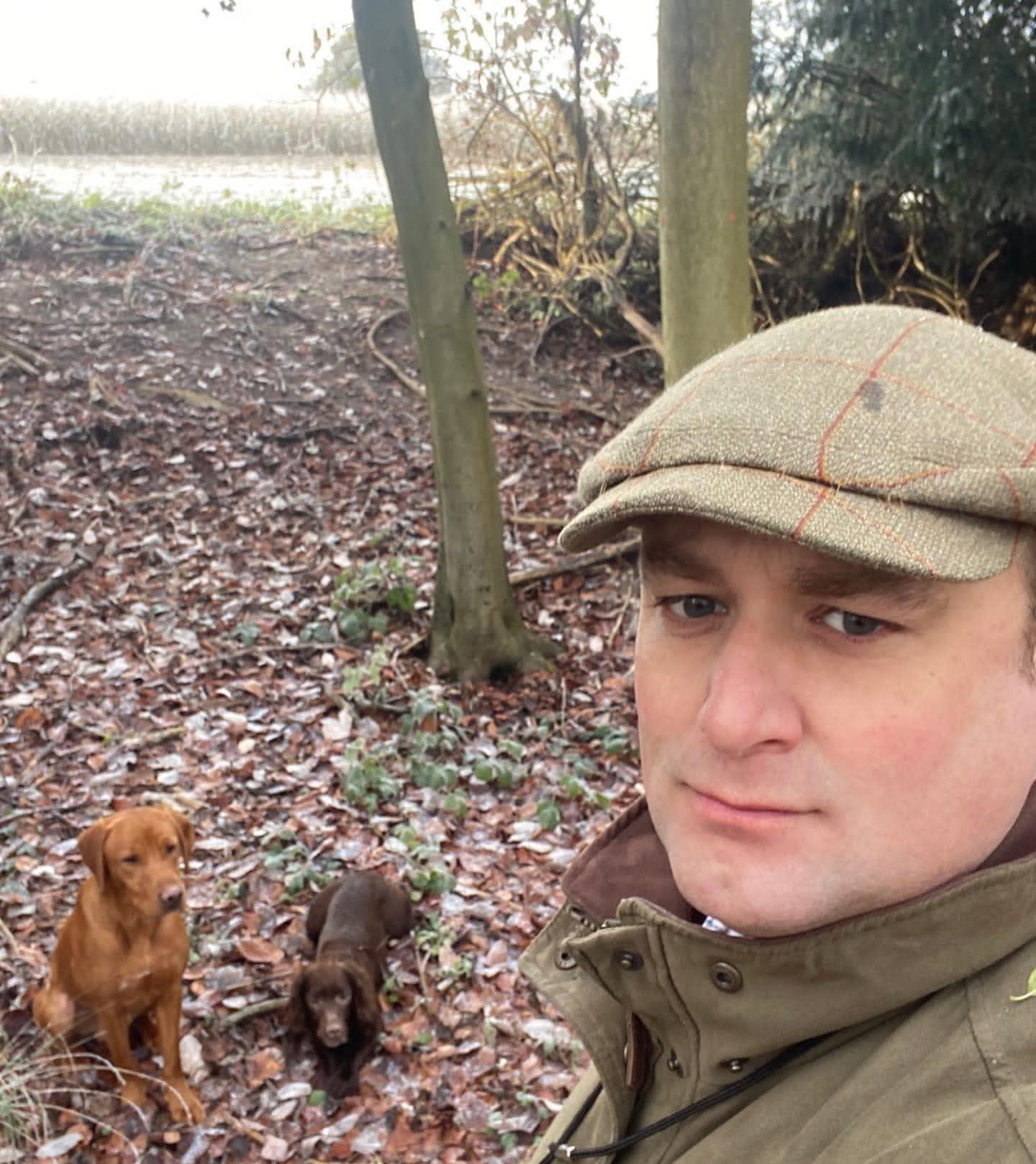 Person in cap with two dogs in woods